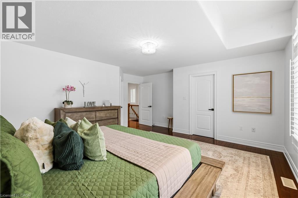 Spacious bedroom featuring wood-finish flooring, white walls, and a tray ceiling - 199 Hunter Street W, Hamilton, ON - Indoor Photo Showing Bedroom