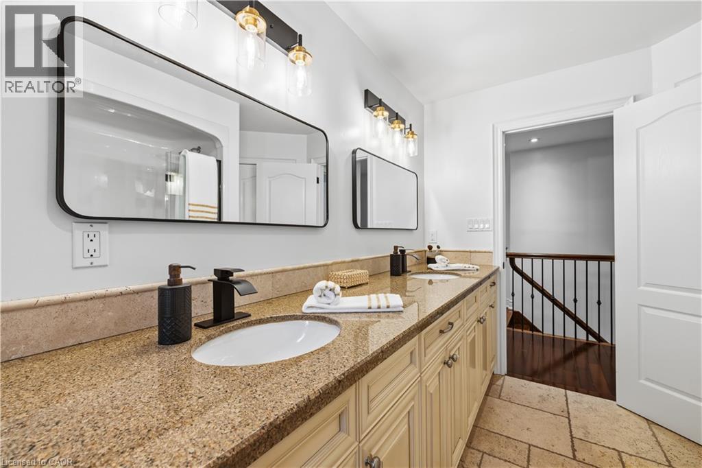 Dual vanity with stone countertop, undermount sinks, and matte black fixtures - 199 Hunter Street W, Hamilton, ON - Indoor Photo Showing Bathroom