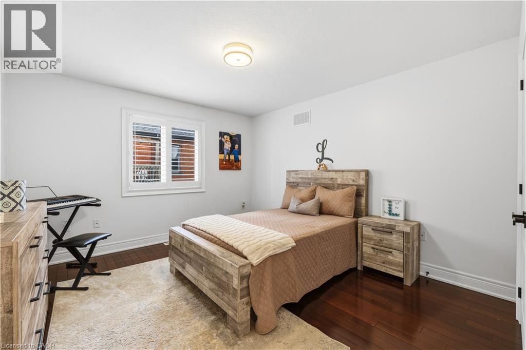 Interior room with dark wood-finish flooring, white walls, and a ceiling-mounted light fixture - 199 Hunter Street W, Hamilton, ON - Indoor Photo Showing Bedroom