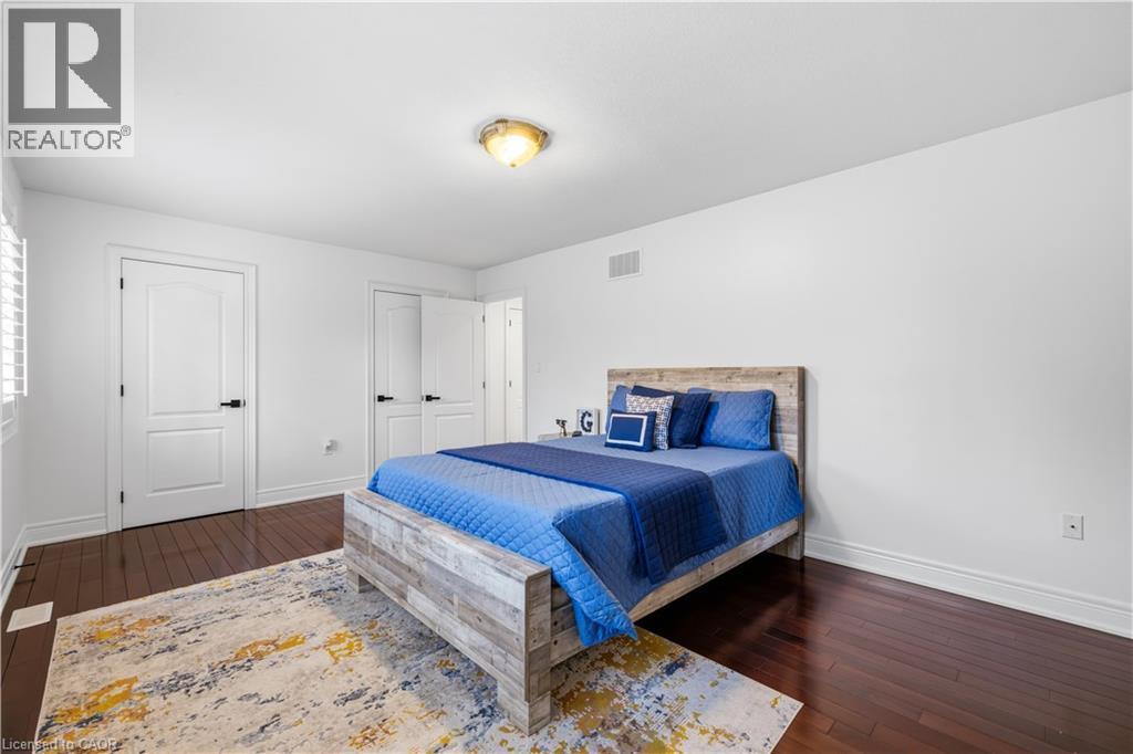 Spacious room featuring dark wood-finish flooring, white baseboards, and white walls - 199 Hunter Street W, Hamilton, ON - Indoor Photo Showing Bedroom