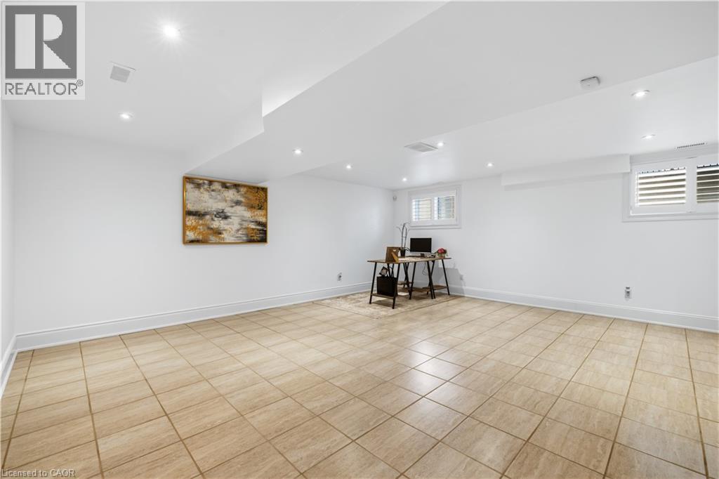 Spacious room featuring light-toned square tile flooring, recessed lighting, and white walls - 199 Hunter Street W, Hamilton, ON - Indoor