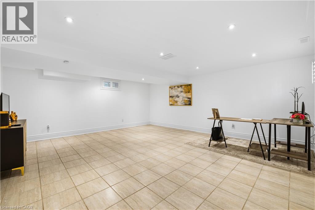 Spacious interior room featuring light-toned square floor tiles and white painted walls - 199 Hunter Street W, Hamilton, ON - Indoor Photo Showing Other Room