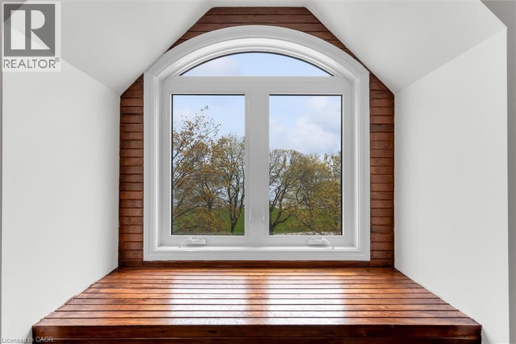Arched window with white framing and sills, complemented by wood-finish wall paneling and a built-in wood-finish window seat - 1389 Lakeshore Road, Burlington, ON - Indoor Photo Showing Other Room