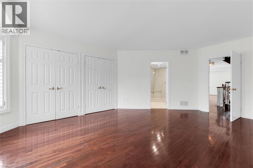 Spacious interior room featuring rich wood-finish flooring, white walls, and bright white trim - 1389 Lakeshore Road, Burlington, ON - Indoor Photo Showing Other Room