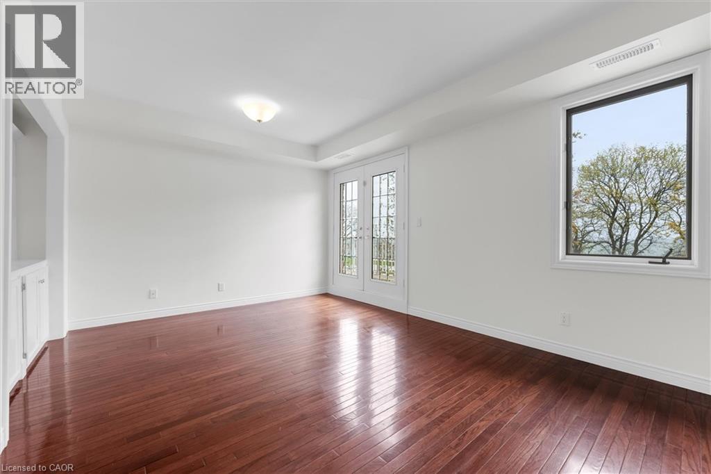 Spacious room featuring rich, wood-finish flooring and pristine white walls - 1389 Lakeshore Road, Burlington, ON - Indoor Photo Showing Other Room