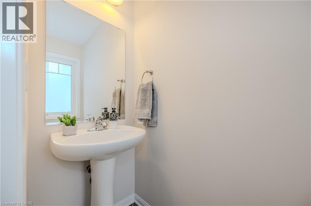 Pedestal sink with chrome faucet, complemented by a rectangular wall-mounted mirror - 525 Cavanagh Lane, Milton, ON - Indoor Photo Showing Bathroom