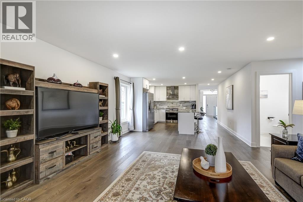 Open-concept living area featuring wood-finish flooring, recessed lighting, and a white color palette - 29 Wiltshire Place, Ancaster, ON - Indoor Photo Showing Living Room
