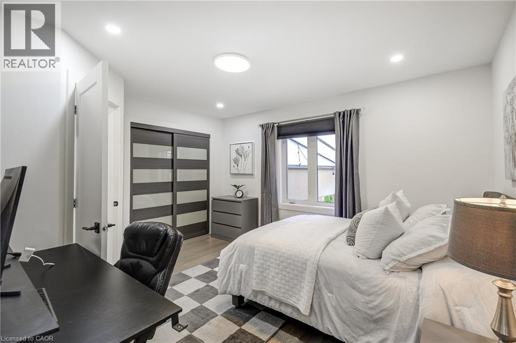 Bedroom featuring light wood-finish flooring, recessed lighting, and a window with dark drapery - 29 Wiltshire Place, Ancaster, ON - Indoor Photo Showing Bedroom