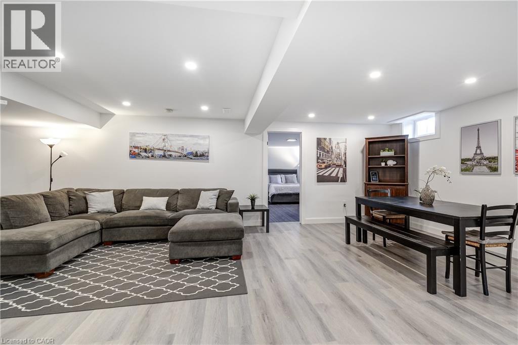 Spacious lower-level living area featuring light wood-finish flooring, recessed lighting, and white walls - 29 Wiltshire Place, Ancaster, ON - Indoor Photo Showing Living Room