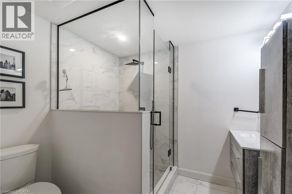 Shower enclosure featuring clear glass panels with matte black trim, a rainfall showerhead, and a handheld spray - 29 Wiltshire Place, Ancaster, ON - Indoor Photo Showing Bathroom