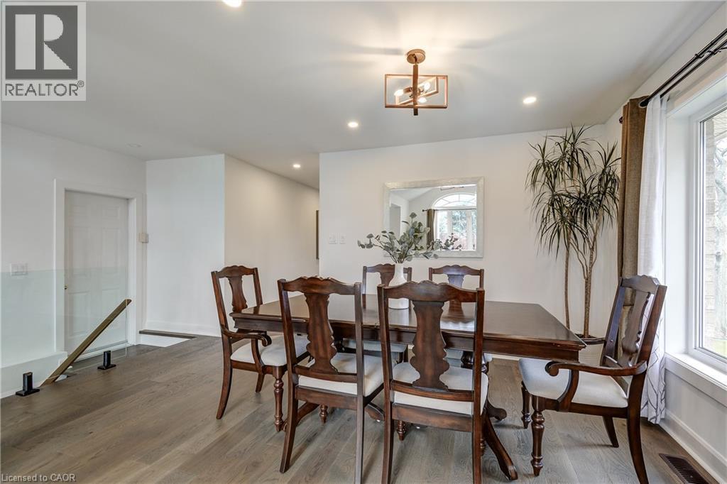 Dining area featuring wood-finish flooring, white walls, and a large window with white trim - 29 Wiltshire Place, Ancaster, ON - Indoor Photo Showing Dining Room