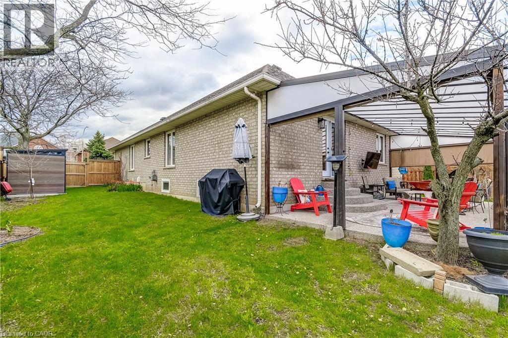 Expansive backyard featuring a lush lawn, a privacy fence, and a patio area with a covered pergola - 29 Wiltshire Place, Ancaster, ON - Outdoor