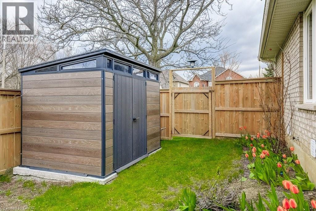 Modern storage shed with wood-finish siding, dark trim, and transom windows - 29 Wiltshire Place, Ancaster, ON - Outdoor