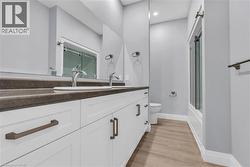 Dual vanity with white cabinetry, dark countertop, and chrome fixtures -