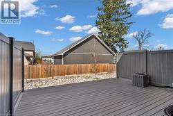 Expansive outdoor deck featuring composite decking, privacy fencing, and a gravel border with natural stone accents -