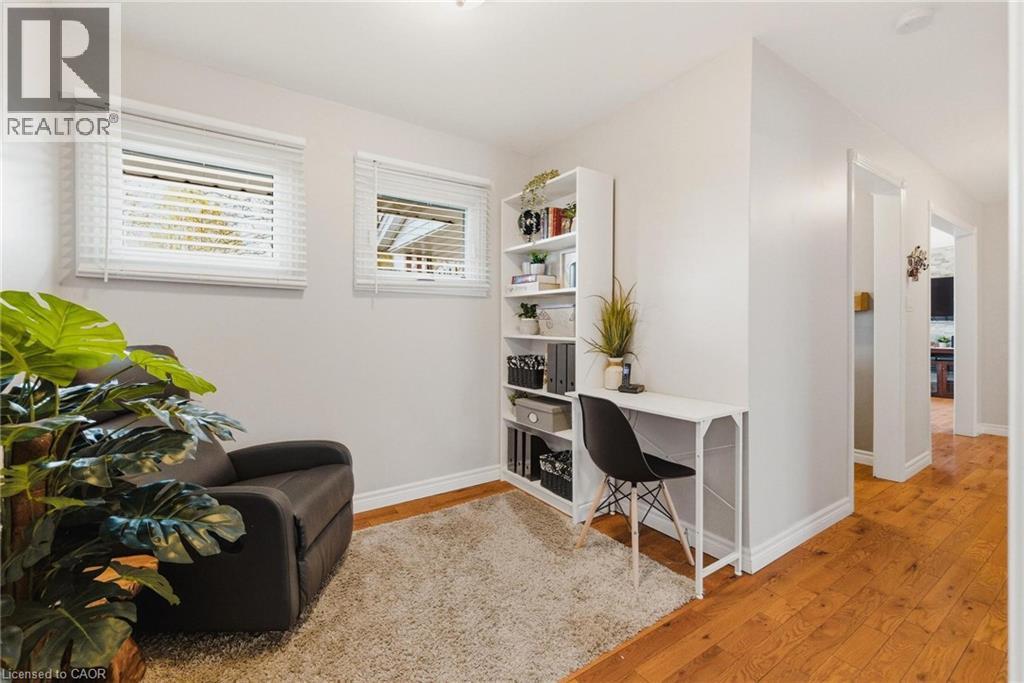 Flexible room featuring two windows with horizontal blinds, light-toned walls, and a plush area rug - 120 Elgin Crescent, Waterloo, ON - Indoor
