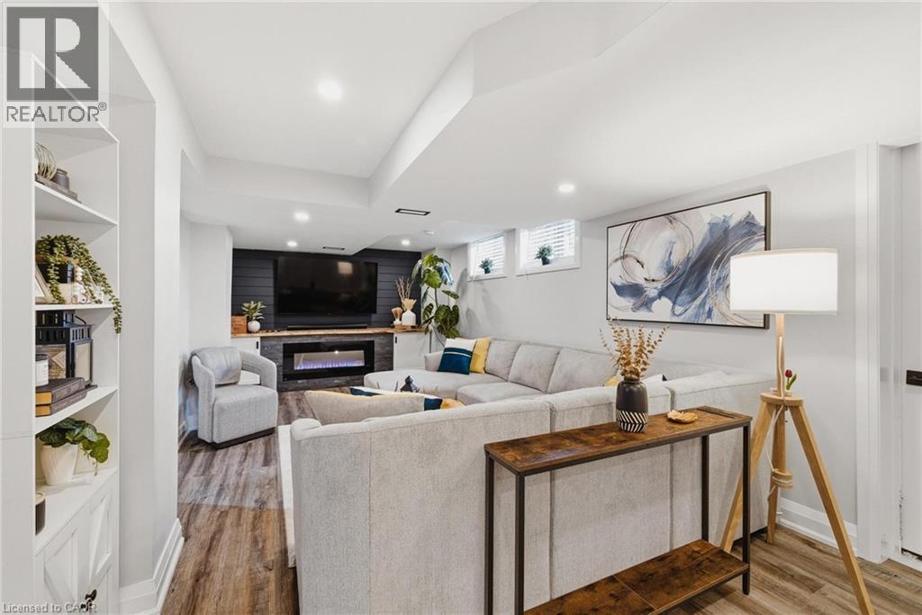 Recessed lighting illuminates wood-finish flooring - 120 Elgin Crescent, Waterloo, ON - Indoor Photo Showing Living Room With Fireplace
