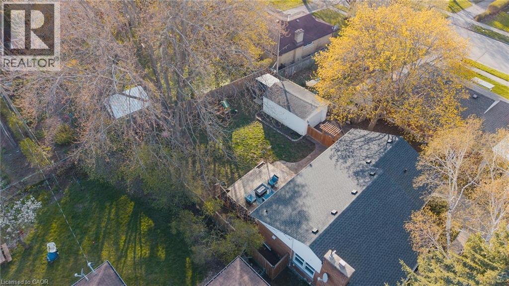 Expansive backyard featuring a manicured lawn, established trees, and a detached shed - 120 Elgin Crescent, Waterloo, ON - Outdoor With View