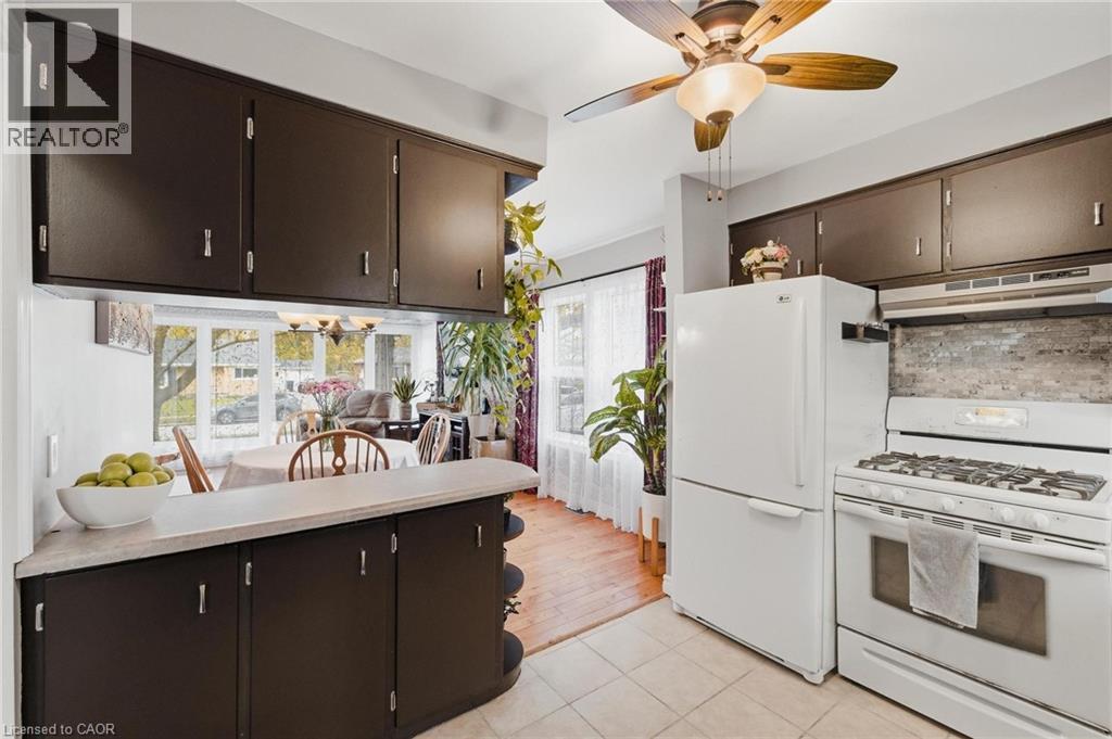Kitchen featuring white appliances, dark cabinetry, and tile flooring - 120 Elgin Crescent, Waterloo, ON - Indoor Photo Showing Kitchen