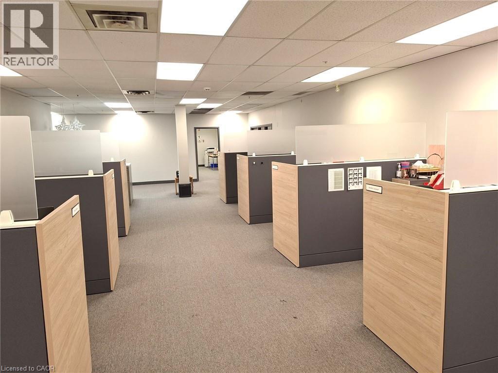 Open-plan office space featuring modular cubicles with wood-finish and gray panels - 920 Sheldon Court, Burlington, ON