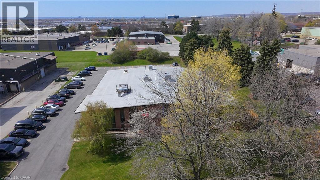 Single-story commercial building featuring a flat roof and multiple rooftop HVAC units - 920 Sheldon Court, Burlington, ON
