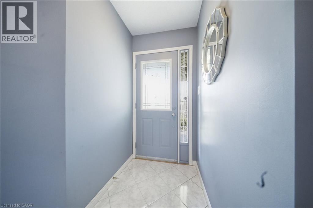 Entryway featuring a decorative main door with frosted glass inserts, a coordinating sidelight, and ceramic tile flooring - 200 Morrison Drive, Caledonia, ON - Indoor Photo Showing Other Room