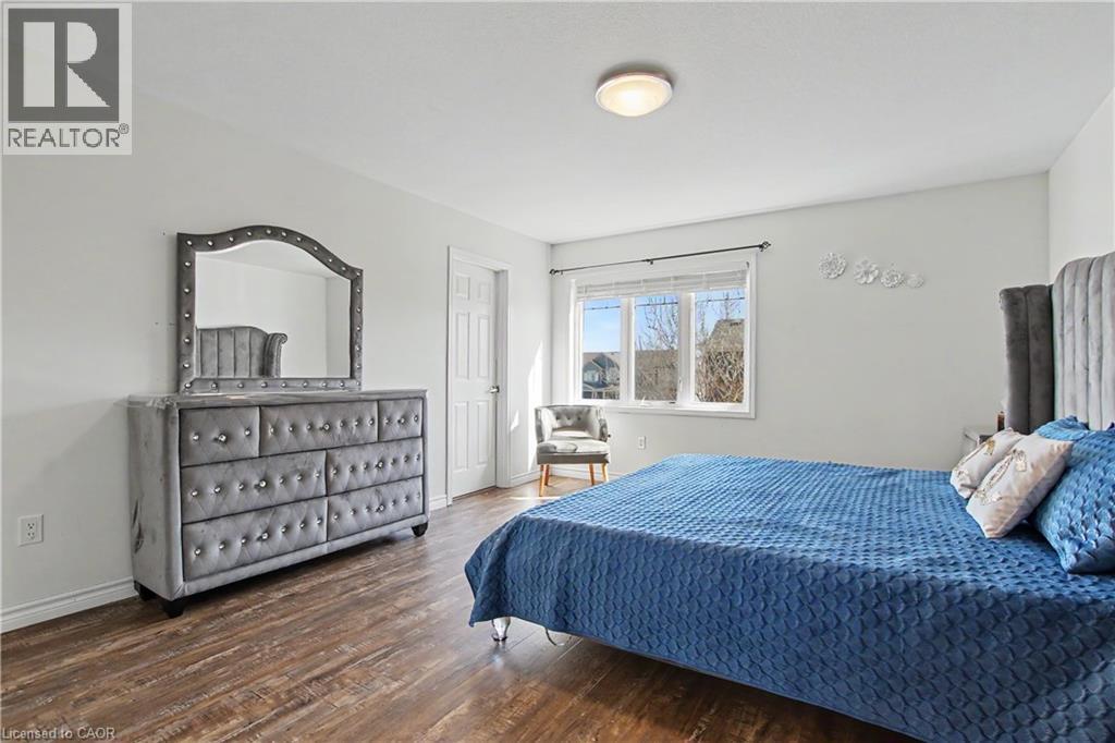 Spacious room featuring wood-finish flooring, white walls, and a ceiling-mounted light fixture - 60 Postmaster Drive, Kitchener, ON - Indoor Photo Showing Bedroom