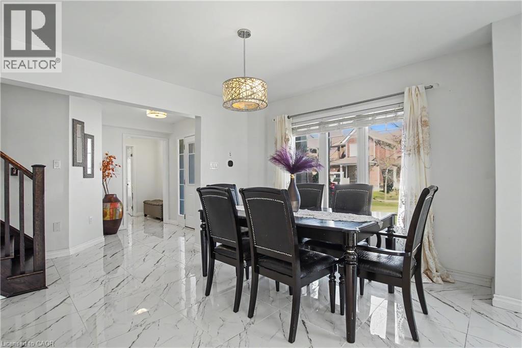 Spacious dining area featuring large format marble-look tile flooring, a decorative chandelier, and a bright window with exterior views - 60 Postmaster Drive, Kitchener, ON - Indoor Photo Showing Dining Room