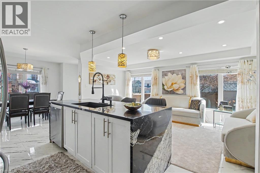 Contemporary kitchen island featuring a black granite countertop and integrated sink with a matte black faucet - 60 Postmaster Drive, Kitchener, ON - Indoor Photo Showing Kitchen