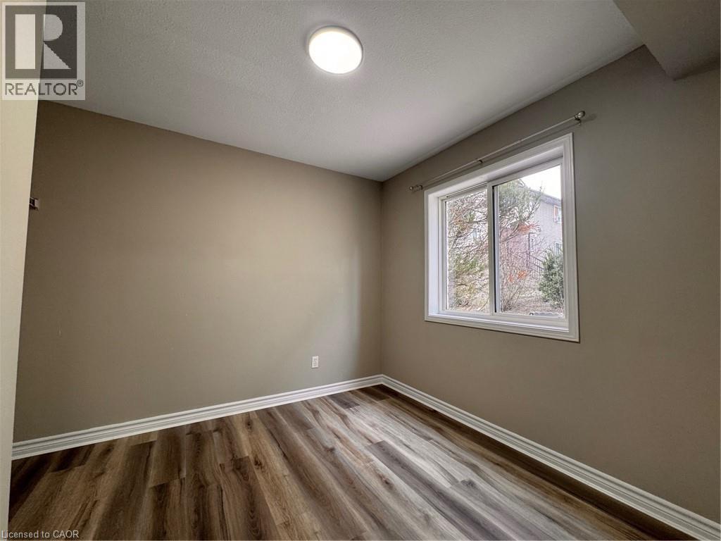 Room featuring wood-finish flooring, neutral wall tones, and white trim - 44 Walnut Street Unit# E01, Kitchener, ON - Indoor Photo Showing Other Room