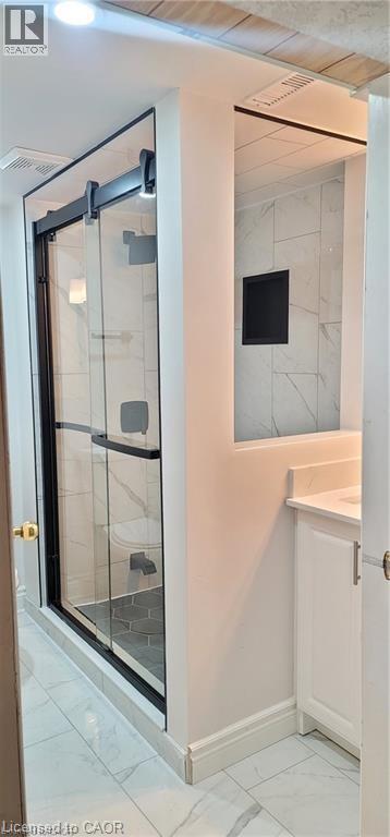 Bathroom featuring a frameless glass shower enclosure with matte black hardware, white tile flooring, white vanity with integrated sink, and recessed lighting - 716 Westminster Drive S Unit# Lower, Cambridge, ON - Indoor Photo Showing Other Room