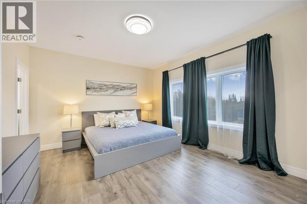 Spacious room featuring wood-finish flooring, a contemporary ceiling light fixture, and crown molding - 6 Dorothys Drive, Oro-Medonte, ON - Indoor Photo Showing Bedroom