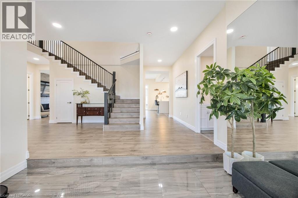 Spacious entryway featuring large format tile flooring, wood-finish flooring, a contemporary staircase with black railings, recessed lighting, and crisp white trim - 6 Dorothys Drive, Oro-Medonte, ON - Indoor Photo Showing Other Room
