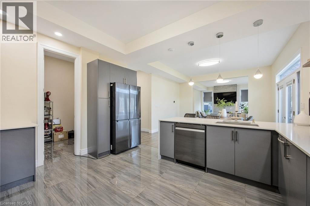 Open-concept kitchen featuring gray cabinetry, stainless steel appliances, a large island with sink, and light-toned countertops - 6 Dorothys Drive, Oro-Medonte, ON - Indoor Photo Showing Kitchen With Upgraded Kitchen