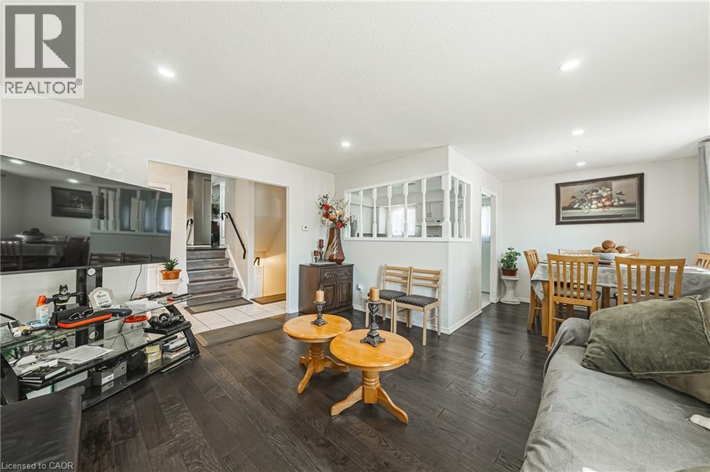 Open concept living area featuring dark wood-finish flooring, recessed lighting, and a white color palette - 235 Larch Street, Hamilton, ON - Indoor Photo Showing Living Room