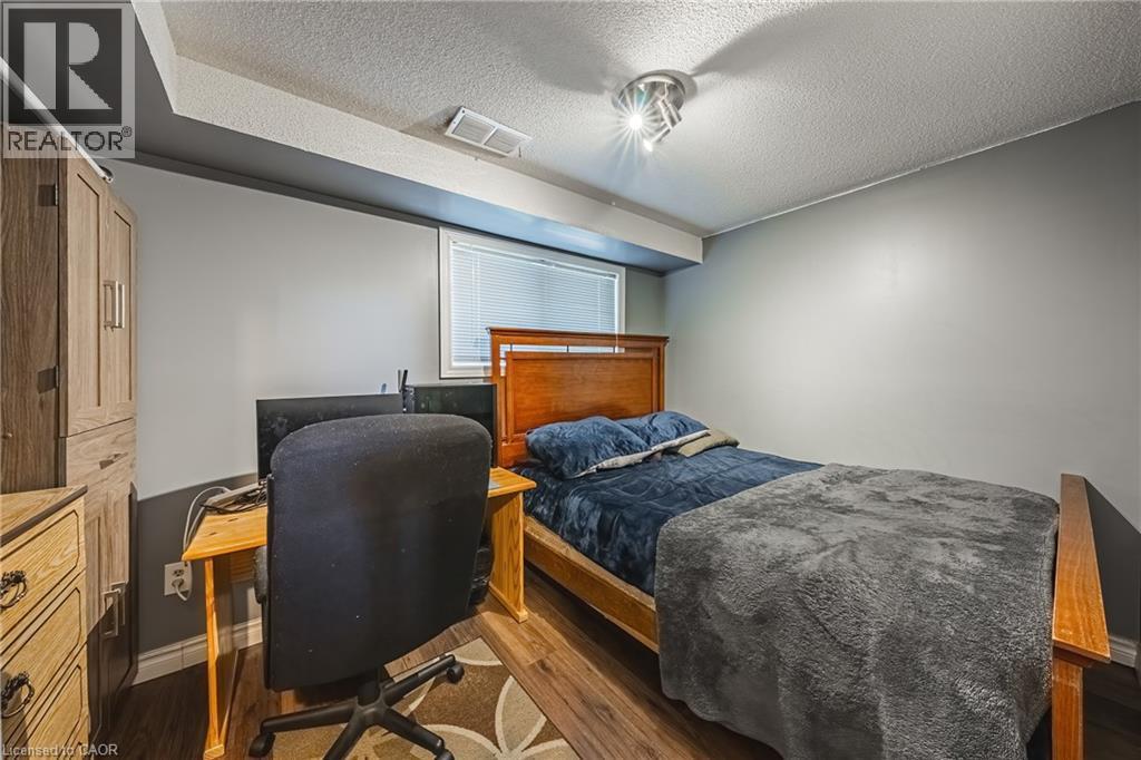 Room featuring neutral gray walls and wood-finish flooring - 235 Larch Street, Hamilton, ON - Indoor
