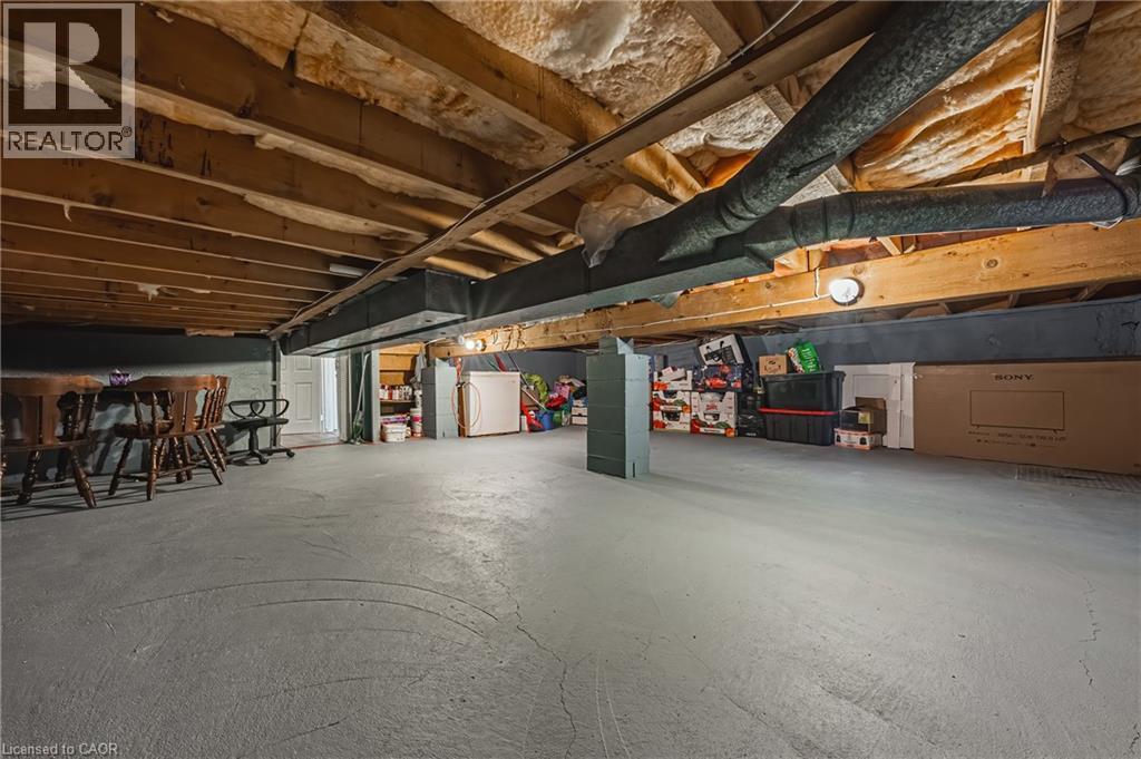 Unfinished basement featuring exposed wood joists, structural beams, and concrete flooring - 235 Larch Street, Hamilton, ON - Indoor