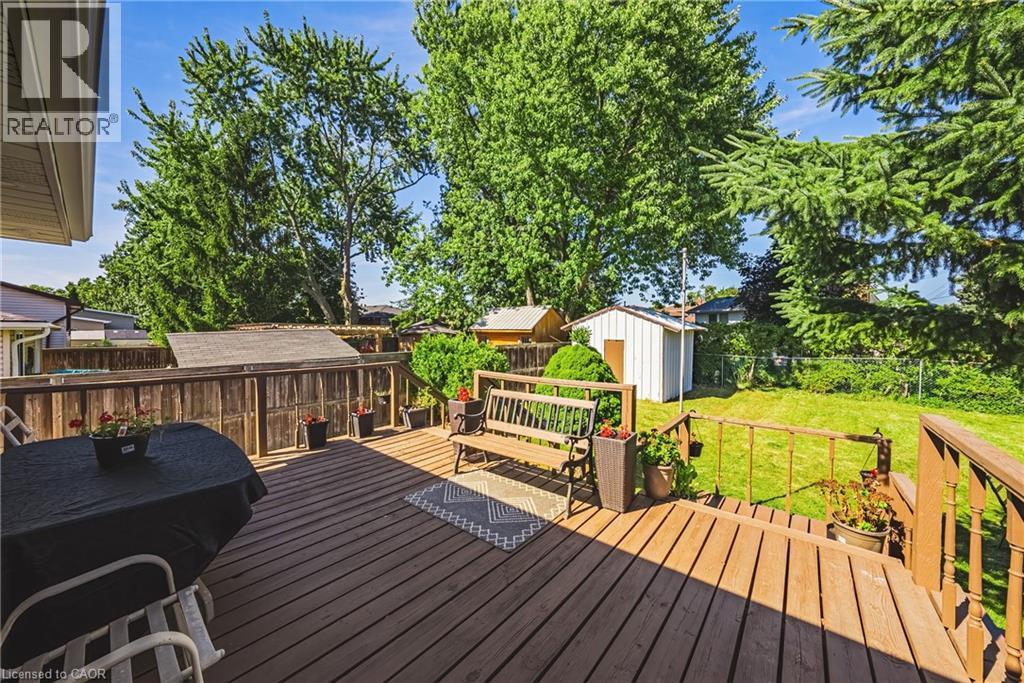 Expansive wood-finish deck with railing overlooking a green lawn - 235 Larch Street, Hamilton, ON - Outdoor With Deck Patio Veranda