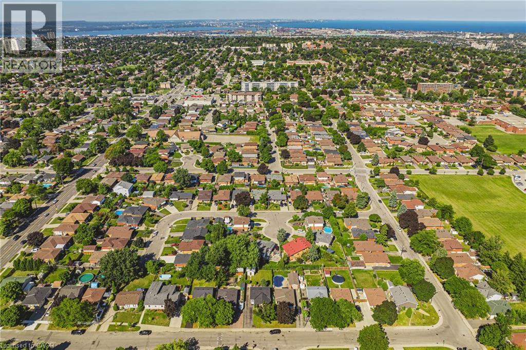 Expansive suburban residential area featuring numerous detached homes, mature tree coverage, and a distant body of water - 235 Larch Street, Hamilton, ON - Outdoor With View