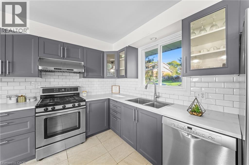 Updated kitchen featuring gray shaker-style cabinetry, white subway tile backsplash, stainless steel appliances, and a double basin sink - 183 Harvard Road, Waterloo, ON - Indoor Photo Showing Kitchen With Double Sink