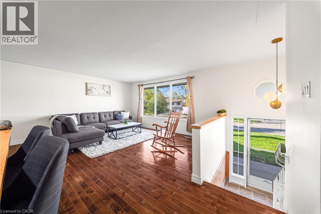 Spacious living area featuring rich wood-finish flooring and ample natural light from large windows - 183 Harvard Road, Waterloo, ON - Indoor Photo Showing Living Room