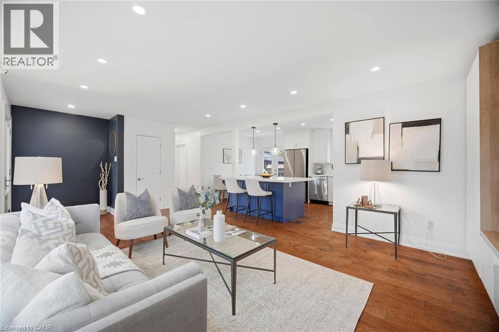 Open-concept living area featuring rich wood-finish flooring, recessed lighting, and a contrasting accent wall - 1376 Royal Drive, Burlington, ON - Indoor Photo Showing Living Room