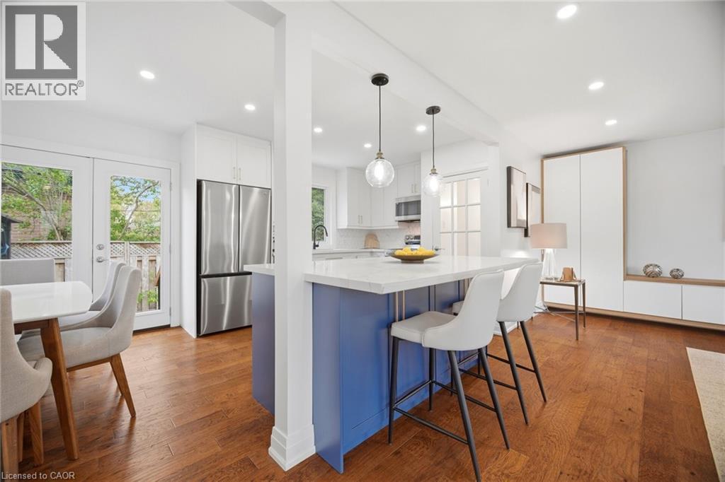 Bright kitchen featuring a blue island with a white countertop, two pendant lights, and recessed lighting - 1376 Royal Drive, Burlington, ON - Indoor Photo Showing Dining Room