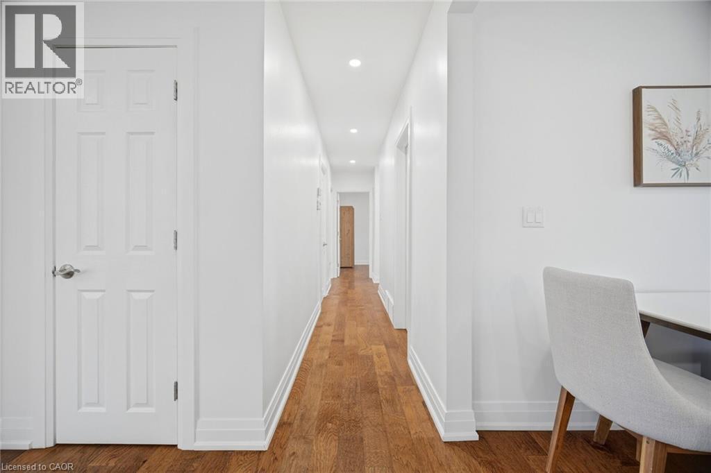 Hallway featuring wood-finish flooring, recessed lighting, white trim, and a white six-panel door - 1376 Royal Drive, Burlington, ON - Indoor Photo Showing Office