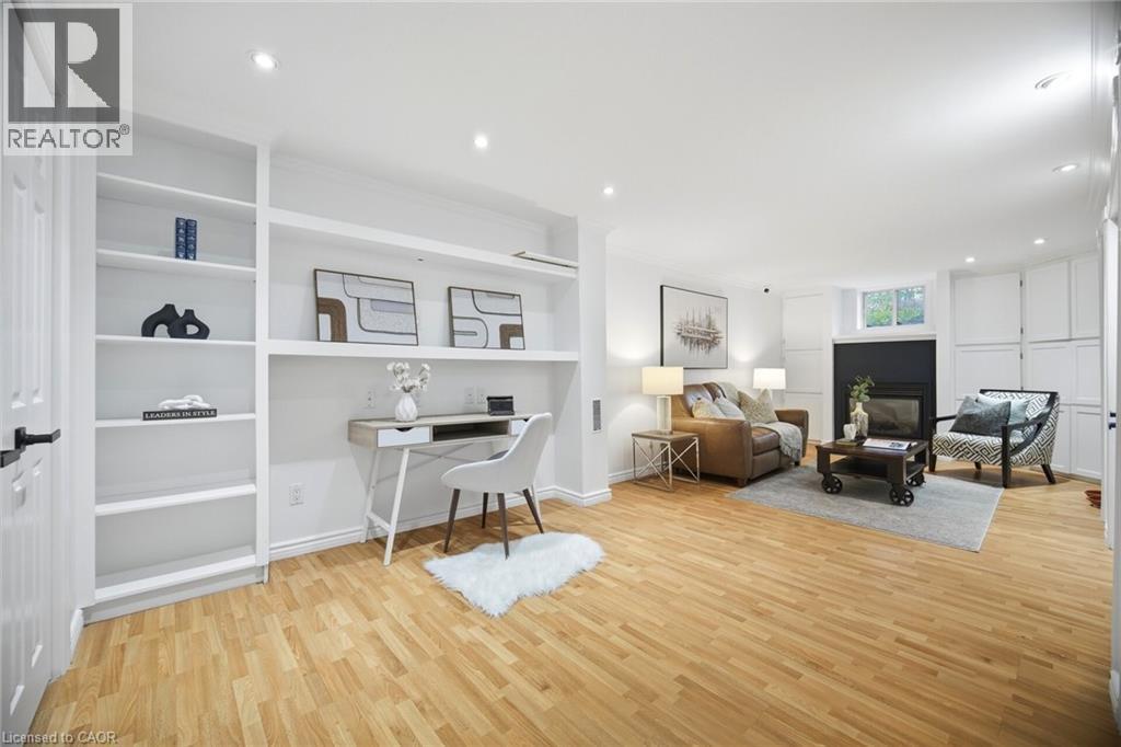 Open-concept living space featuring wood-finish flooring, recessed lighting, and a built-in shelving unit with desk alcove - 1376 Royal Drive, Burlington, ON - Indoor