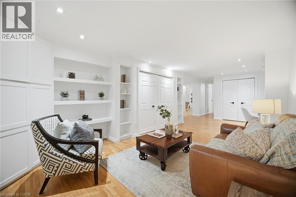 Living area with wood-finish flooring, recessed lighting, and white built-in shelving - 1376 Royal Drive, Burlington, ON - Indoor Photo Showing Living Room