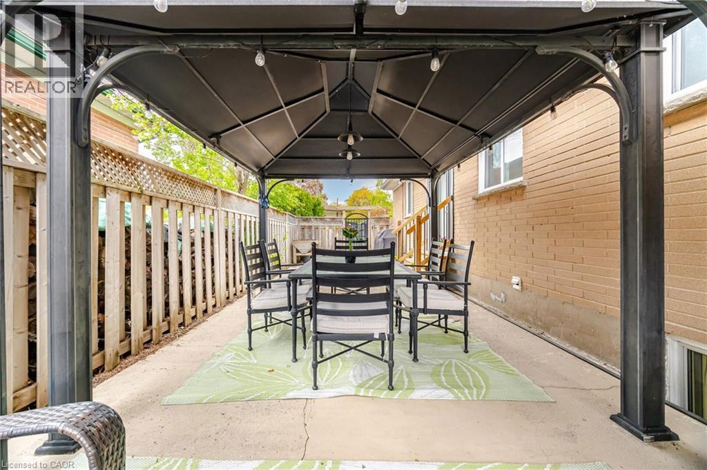 Expansive concrete patio featuring a permanent gazebo with built-in string lighting - 1376 Royal Drive, Burlington, ON - Outdoor With Deck Patio Veranda With Exterior