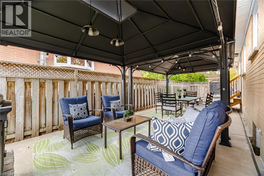Paved patio with a black gazebo featuring integrated lighting fixtures - 1376 Royal Drive, Burlington, ON - Outdoor With Deck Patio Veranda With Exterior