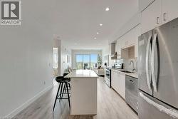 Kitchen featuring appliances with stainless steel finishes, a kitchen island, white cabinets, modern cabinets, and recessed lighting -