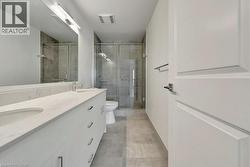 Full bathroom with double vanity, a stall shower, and tile patterned floors -